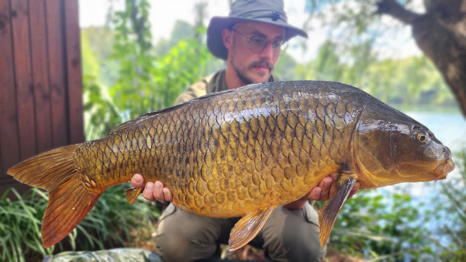 A common carp held beside the lodge