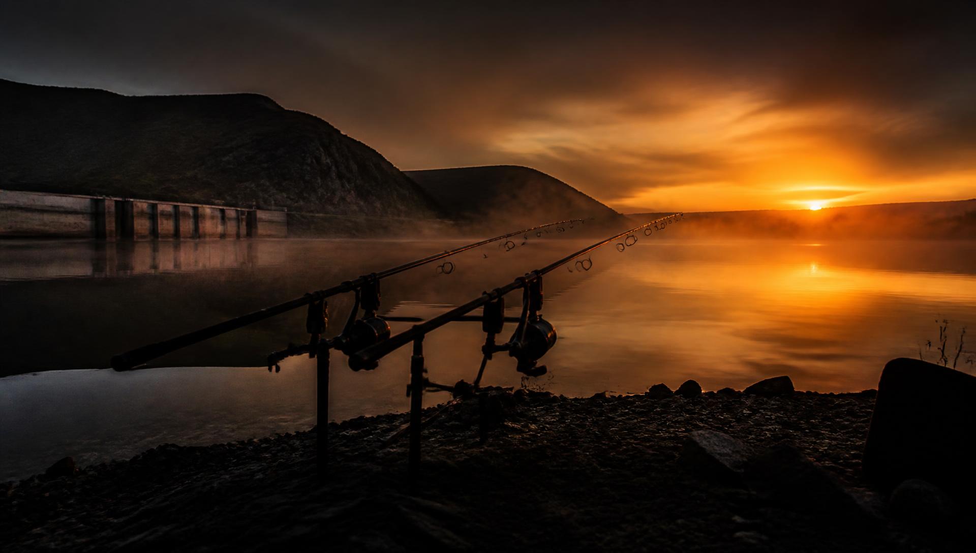 Carp rods on a rod pod at sunrise over a South African dam